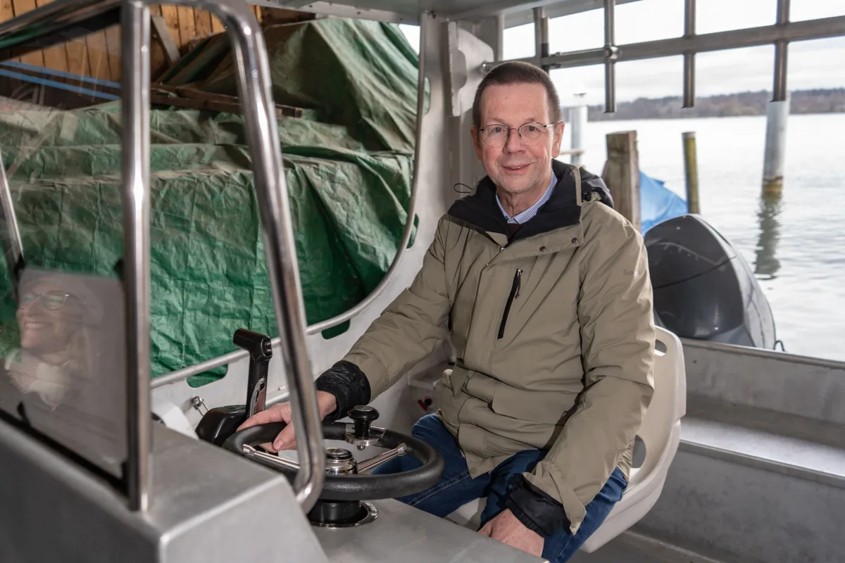 Piet Spaak sitzt am Lenkrad des Forschungsboots der Eawag und blickt in die Kamera.